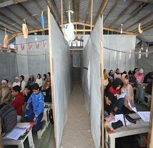 أطفال نازحون يتلقون دروساً داخل خيمة في اليرموك بـغزة، بعد تدمير معظم المدارس وتحويل بعضها لمراكز إيواء بسبب الحرب.