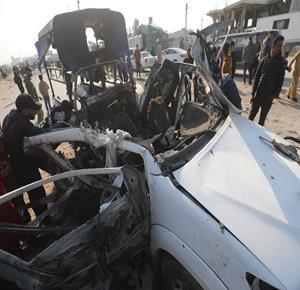 مواطنون يتفقدون مركبة تعرضت لقصف الاحتلال قرب مدينة الزوايدة في وسط قطاع غزة