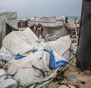  نازحون يتفقدون خيامهم بعد أن تضررت جراء عاصفة هوائية قوية ضربت مخيماً للنازحين في المحافظة الوسطى بقطاع غزة