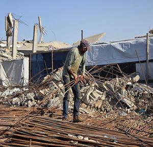 مواطنون يستخرجون حديد البناء من المباني التي دمرها الاحتلال لإعادة تدويره واستخدامه في بناء الخيام والملاجئ المؤقتة