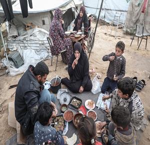 عائلة نازحة تتناول الإفطار في خيمة متهالكة داخل مخيم النصيرات، وسط ظروف معيشية قاسية وشحّ في المساعدات الإنسانية