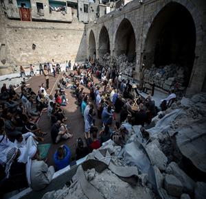 مواطنون يؤدون صلاة الجمعة في مسجد عمر الكبير بمدينة غزة الذي تعرض لأضرار جسيمة خلال العدوان الإسرائيلي