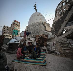 عائلة نازحة من بيت حانون تتناول إفطار رمضان في خيمة بين ركام مسجد الحساينة على شاطئ غزة