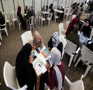 طلبة يتقدمون لاختبارات الثانوية العامة "التوجيهي" إلكترونياً داخل أحد المقاهي في مخيم البريج، في ظل لجوء الطلبة إلى أماكن توفر خدمة الإنترنت بعد تدمير معظم المدارس واستمرار انقطاعهم عن التعليم الوجاهي للعام الثالث على التوالي