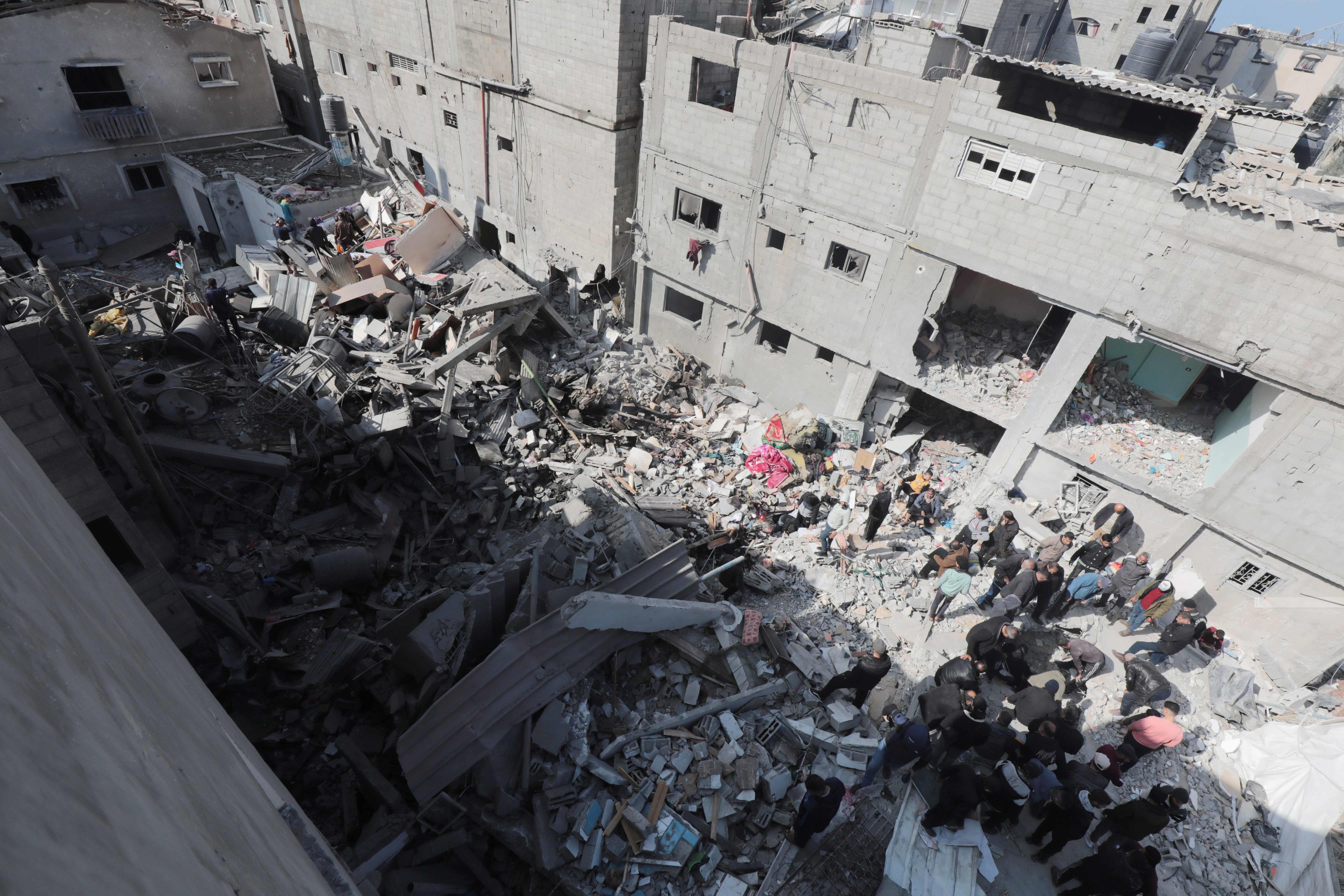 مواطنون يتفقدون الدمار بعد قصف الطائرات الحربية الإسرائيلية لعدد من المنازل في مخيم النصيرات وسط قطاع غزة (وفا)